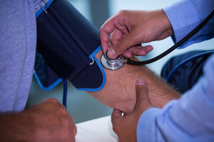 Male doctor checking blood pressure of patient at the hospital